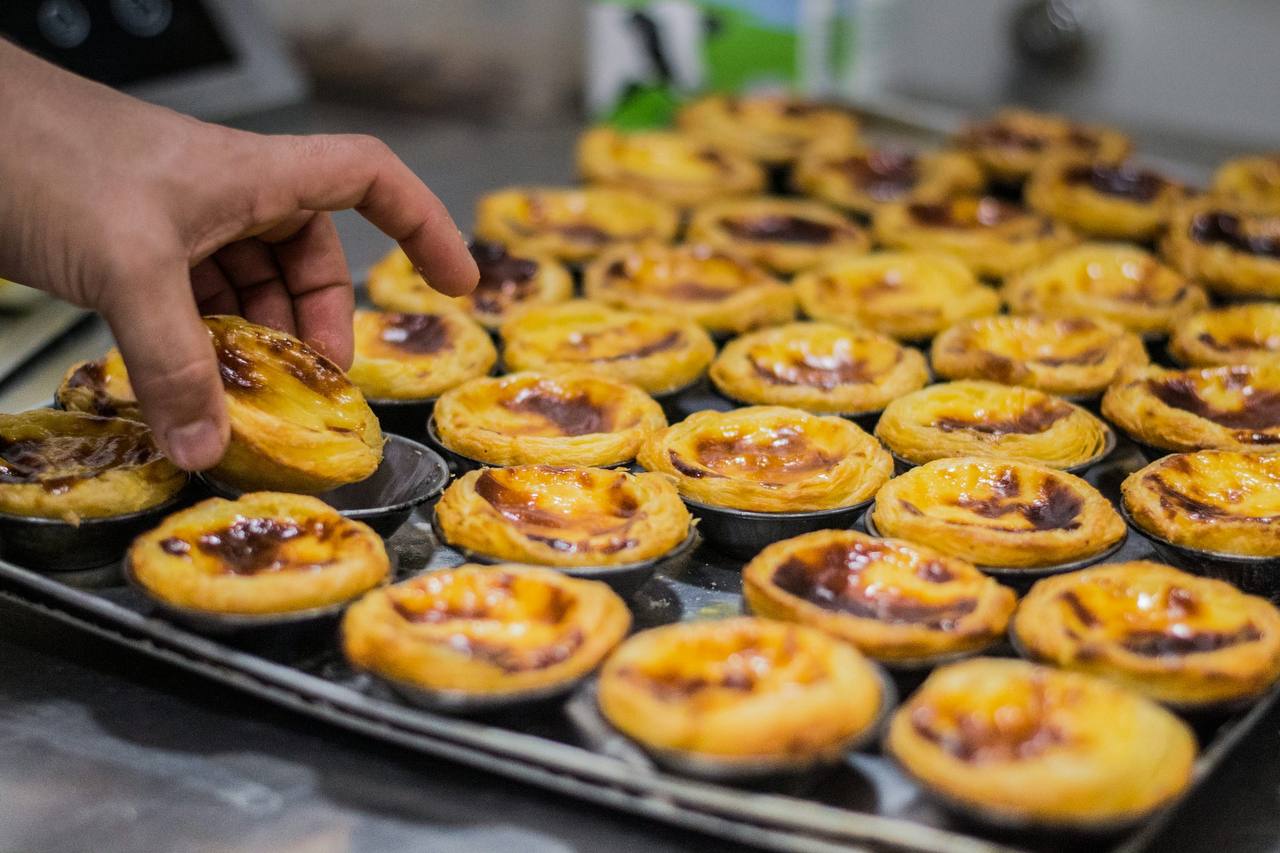 A fresh tray of pastéis de nata with caramelized cinnamon-dusted tops.