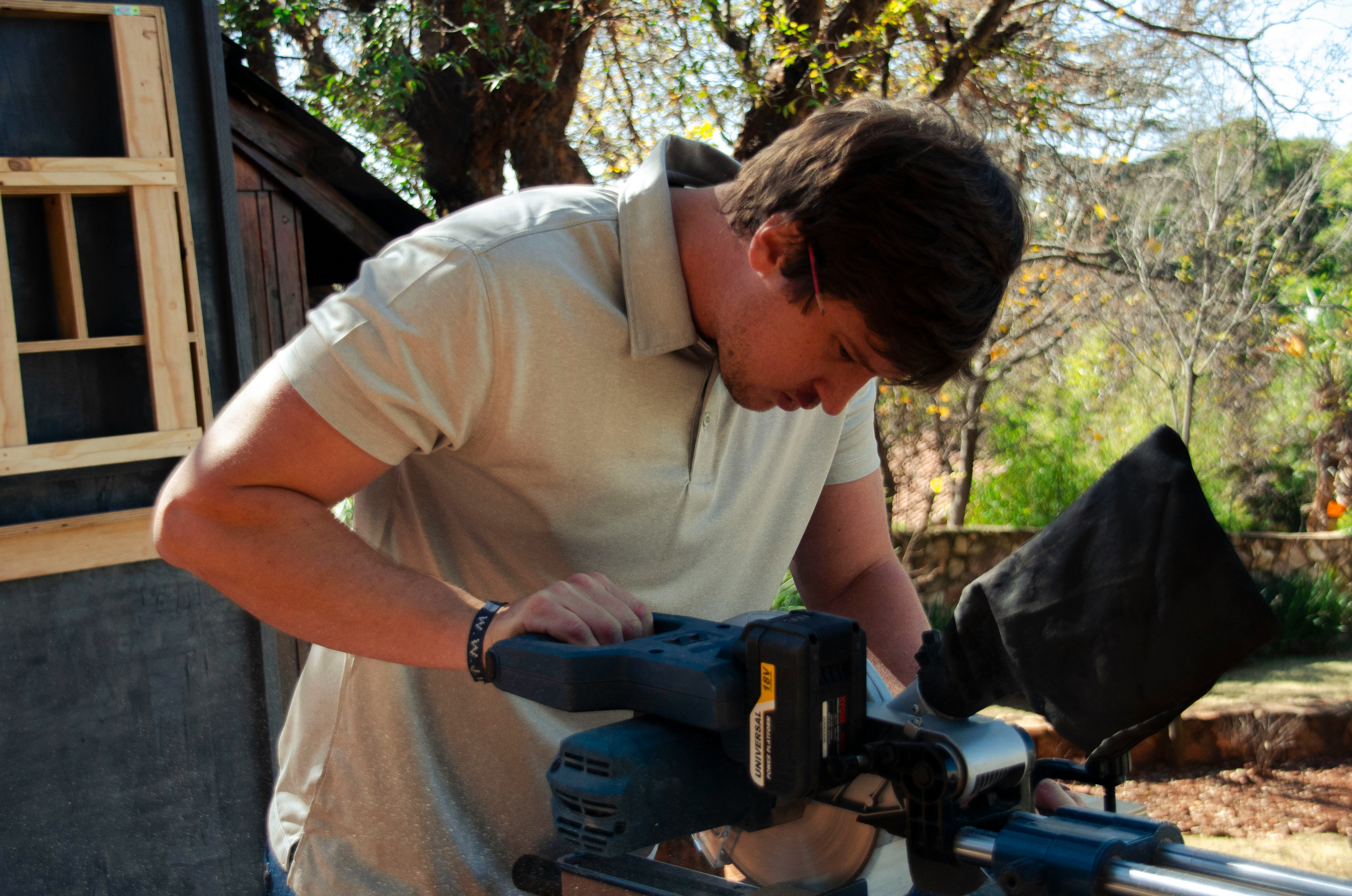 A young craftsman working with a miter saw -- the kind of hands-on business owner Hammer and Pixels builds websites for.